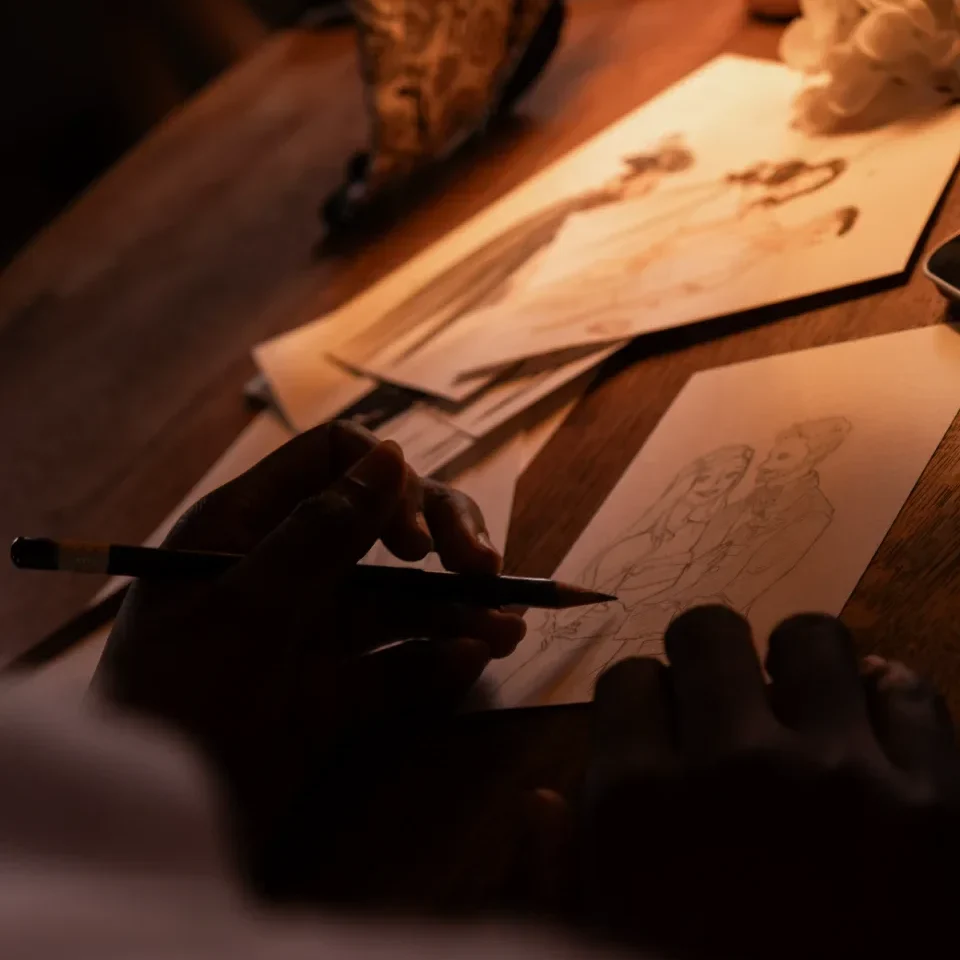 Mains d'une artiste dessinant au crayon un portrait de couple