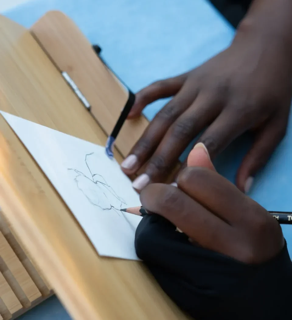 Mains entrain de dessiner un portrait au crayon